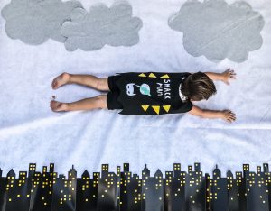 Batman kids' birthday party decor; aerial shot of a toddler flying in a cape