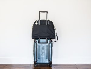 Black Lo and Sons Travel Bag on top of Tumi rolling carry on bag